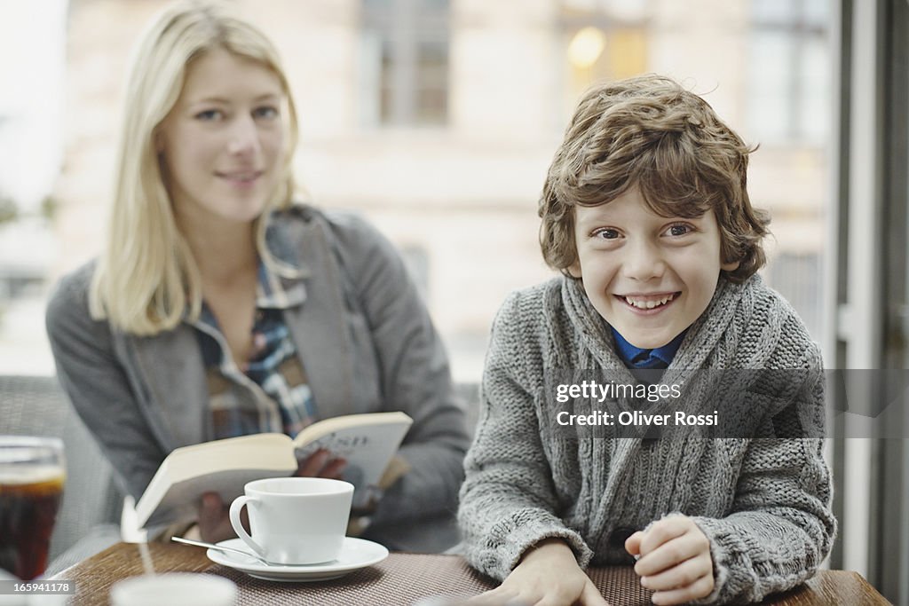 Smiling boy with mother in a café