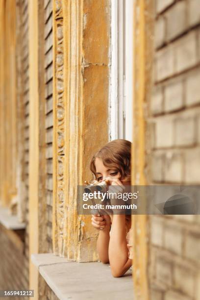 la ragazza guardando fuori dalla finestra con binocolo da teatro - binocolo da teatro foto e immagini stock