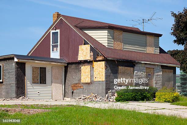 damaged destroyed boarded-up abandoned house - dichtgetimmerd stockfoto's en -beelden