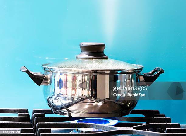 saucepan boiling on gas stove with steam jet rising - deksel stockfoto's en -beelden