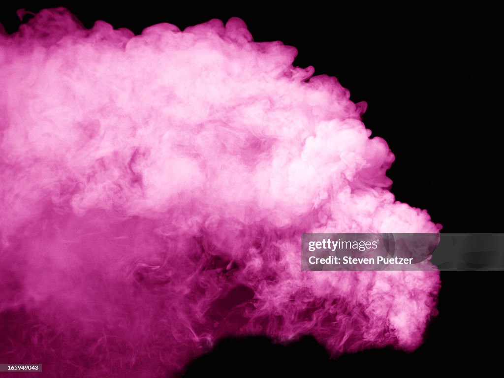 Pink smoke against black background