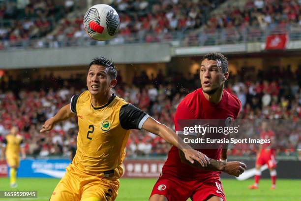 Muhammad 'Afi Bin Aminuddin of Brunei Darussalam fights for the ball with Everton Camargo of Hong Kong during the international friendly between Hong...