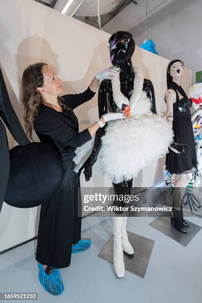 Staff member adjusts Bjork's 'swan' dress form the Oscars in 2001 by Marjan Pejoski during a photocall for the upcoming exhibition REBEL: 30 Years of...