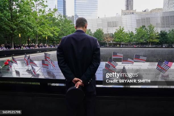 New York firefighter looks at the names on the 9/11 memorial pool on the 22nd anniversary of the terror attack on the World Trade Center, in New York...