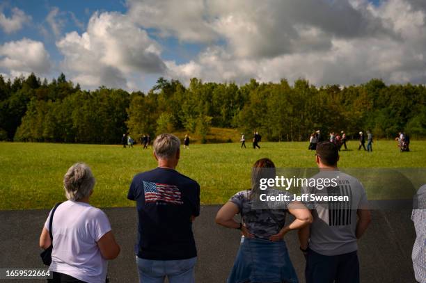 Visitors watch as family members stroll to the crash site during a ceremony commemorating the 22nd anniversary of the crash of Flight 93 during the...