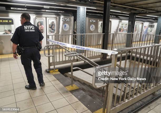 September 8: A NYPD counter terrorism officer stands by crime scene tape as NYPD officers investigate a "novelty" grenade found on the Southbound...