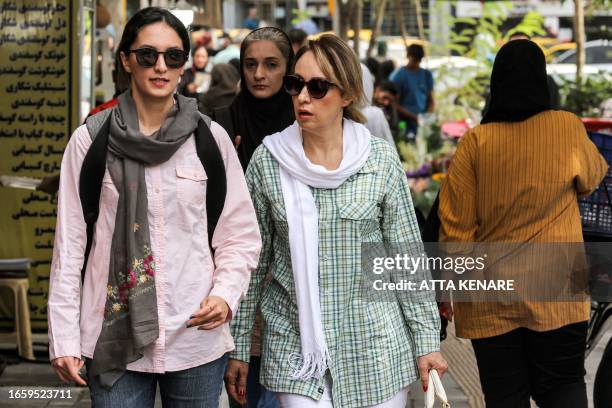 Women walk along Vanak Square in central Tehran on September 4, 2023. A year after the death of Mahsa Amini sparked unrest across Iran, the issue of...