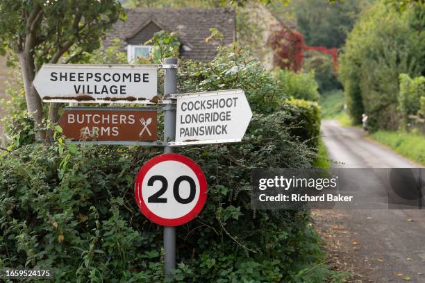 Rural signposts to a local pub and nearby villages plus a 20mph speed limit in the Cotswolds village of Sheepscombe, on 8th September 2023, near...