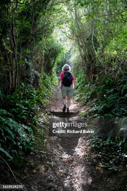 With the help of walking poles, a woman walks up a steep hill on the Cotswolds Way, on 8th September 2023, in Wotton-under-Edge, England. Although...