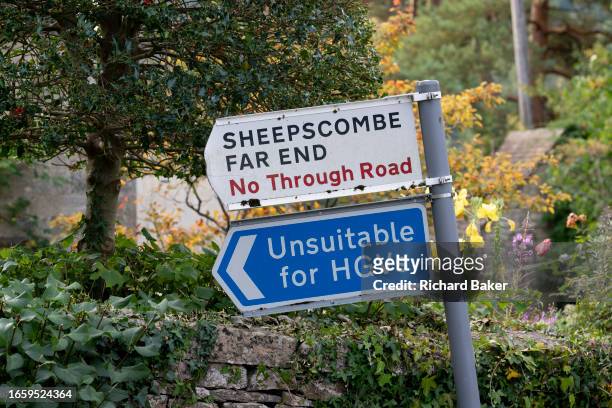 Leaning signpost warns Heavy Goods Vehicles about narrow lanes and a no through road in the Cotswolds village of Sheepscombe, on 8th September 2023,...