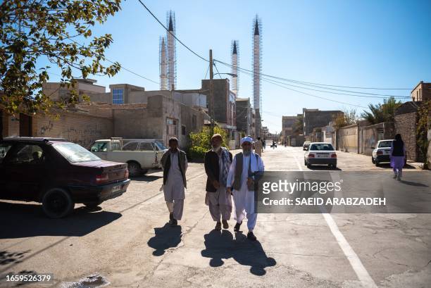 November 30th 2018. Men dressed in traditional Kameez tunics, traditional Balochi dress, walk in the streets near Jameh Mosque of Zahedan, Zahedan,...