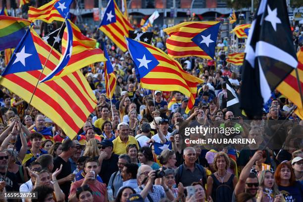 Demonstrators gesture and wave Catalan pro-independence "Estelada" flags as they gather during the "Diada" celebrations, the national day of...