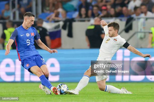 Robert Bozenik of Slovakia and Aron Sele of Liechtenstein battle for the ball during the UEFA EURO 2024 European qualifier match between Slovakia and...