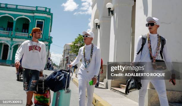 Young Cubans walk down a street in Santa Clara, Villa Clara province, Cuba, on September 11, 2023.