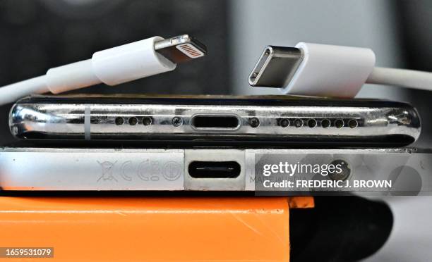 Charger and a traditional Apple Lightning charger are seen on an Apple iPhone with Lightning port above an Android phone with a USB-C port on...