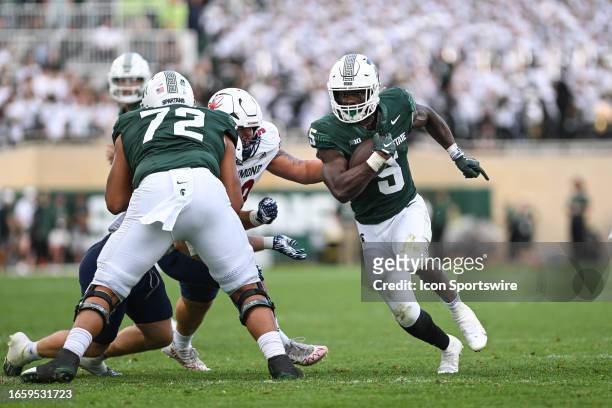 Michigan State Spartans running back Nathan Carter splits past a Richmond defender during a college football game between the Michigan State Spartans...