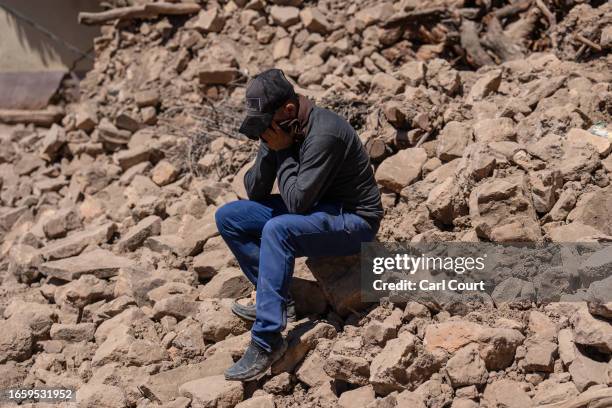 Man is overcome with grief as the body of his 30-year old brother is removed from beneath a collapsed house on September 11, 2023 in Douzrou,...