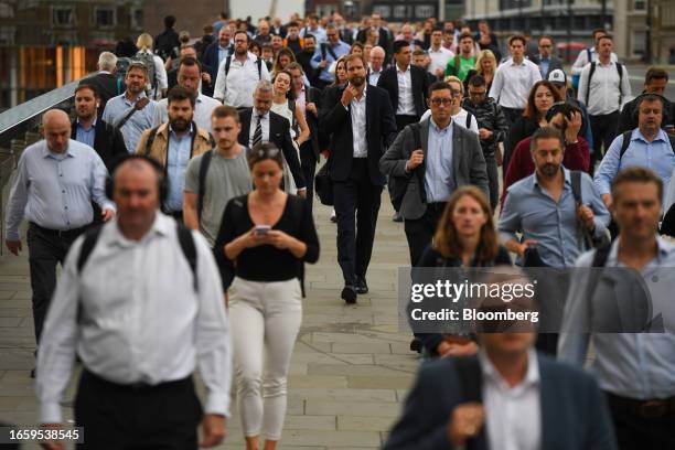 Commuters cross London Bridge in London, UK, on Tuesday, Sept. 12, 2023. UK wage growth held at a record high in the three months through July, a...