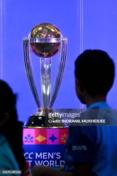 Students look at the ICC Men's Cricket World Cup 2023 trophy on display at a school as part of an official trophy tour in Mumbai on September 12,...