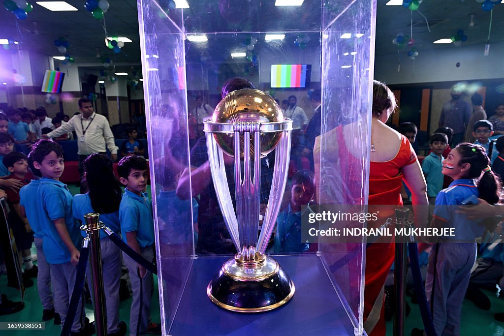 Students look at the ICC Men's Cricket World Cup 2023 trophy on... News ...