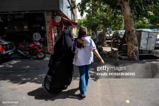 Tehran, Iran. Two Iranian women are walking in the street of Tehran with optional covering.