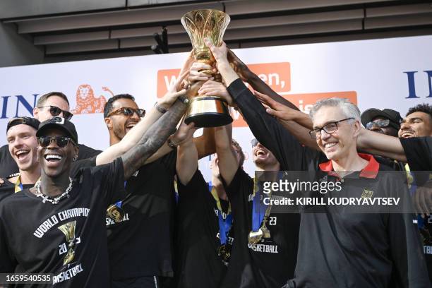 Members of the German Basketball world champions, among them Dennis Schroeder and head coach Gordie Herbert , cheers with their trophy to celebrate...