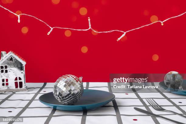 modern xmas table. festive checkered white and red background with christmas recycled toys, disco ball, shining garland, plates and silver candle holder in the form of a house. - white house christmas stock pictures, royalty-free photos & images