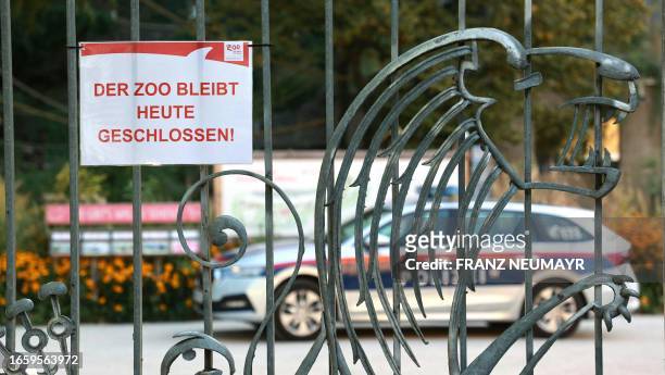 Sign reading "The zoo remains closed today" is attached at the entrance of the Zoo Salzburg , as a police car stands inside, on September 12, 2023 in...