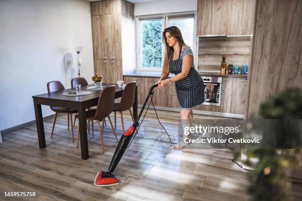 young brunette woman cleaning floor with steam cleaner - mop stock pictures, royalty-free photos & images