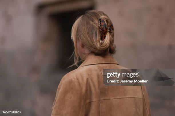 Sonia Lyson seen wearing Miu Miu brown suede leather jacket and a brown tortoise hair clip, on September 03, 2023 in Berlin, Germany.