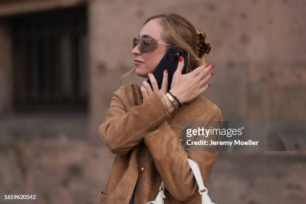 Sonia Lyson seen wearing Miu Miu brown transparent sunglasses, Miu Miu brown suede leather jacket, Miu Miu white leather Pocket bag, brown tortoise...