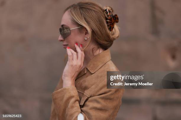 Sonia Lyson seen wearing Miu Miu brown transparent sunglasses, Miu Miu brown suede leather jacket and a brown tortoise hair clip, on September 03,...