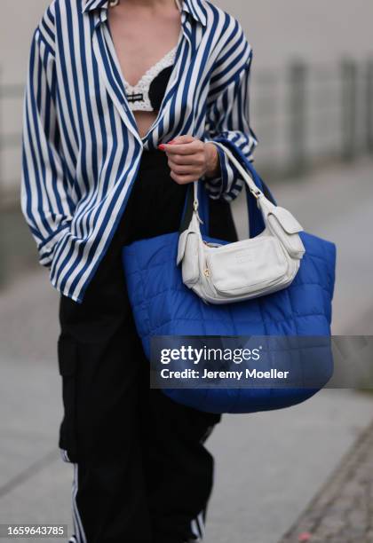 Sonia Lyson seen wearing Zara blue / white striped blouse, Adidas black jogger cargo pants, Miu Miu black / white knit crochet bra, Miu Miu Wandler...