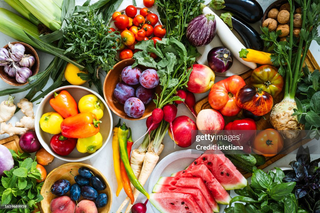 Fresh homegrown vegetables and fruits on kitchen table, summer harvest still life, table top view