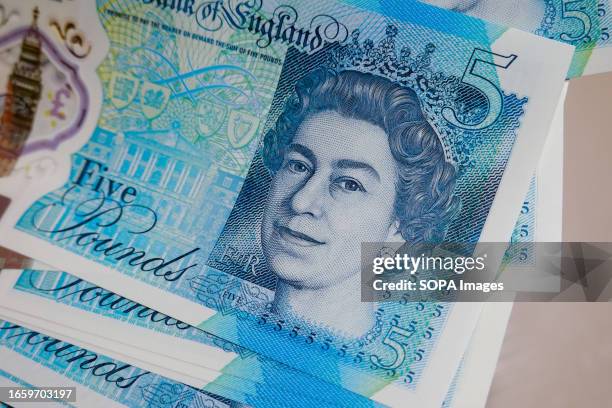 In this photo illustration, some 5 pounds banknotes with Queen Elizabeth II are displayed on a table.