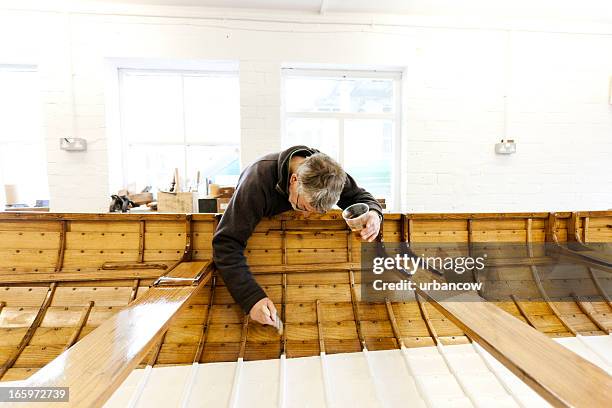 varnishing a gig boat - wooden boat stock pictures, royalty-free photos & images