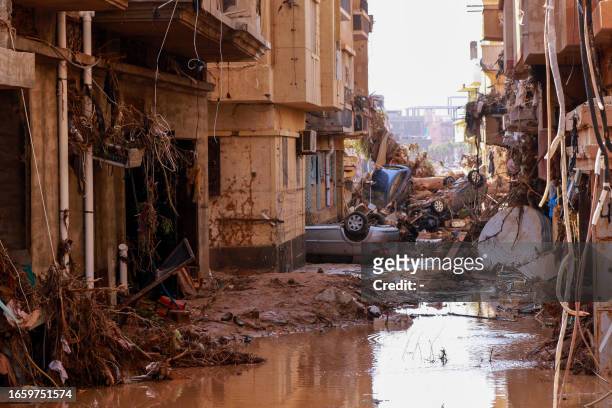 Overturned cars lay among other debris caused by flash floods in Derna, eastern Libya, on September 11, 2023. Flash floods in eastern Libya killed...
