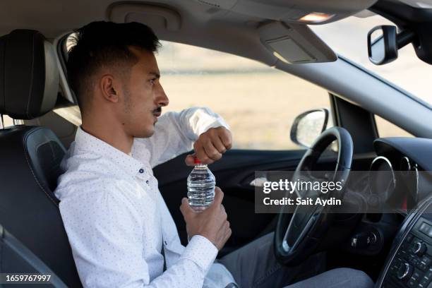 car driver drinking water. - water bottle stock pictures, royalty-free photos & images