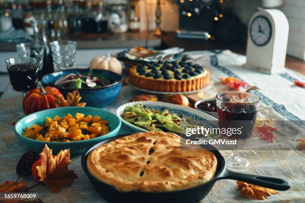 vegan thanksgiving dinner with pumpkin & kale pot pie, butternut squash, roasted green beans with almond bacon, radicchio clementine salad and berry pie - pie stockfoto's en -beelden