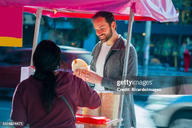 man buying wafer on the street from a street vendor - wafer stock pictures, royalty-free photos & images