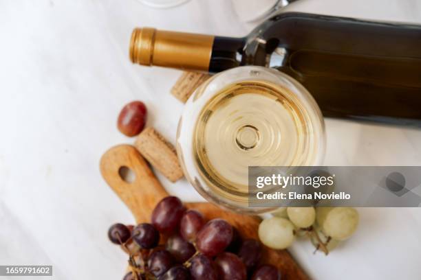 glases of white wine and red wine and bottles of red and white wine and fresh grapes - bordeaux bottle stock pictures, royalty-free photos & images