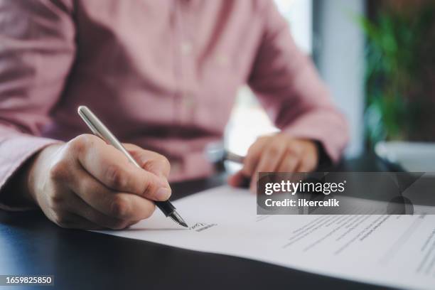 businesswoman signing an official document - erfenis stockfoto's en -beelden