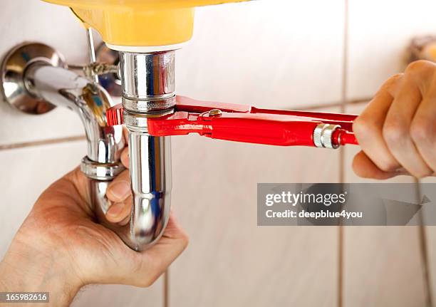klempner-fixierung ein waschbecken im badezimmer - red tube stock-fotos und bilder