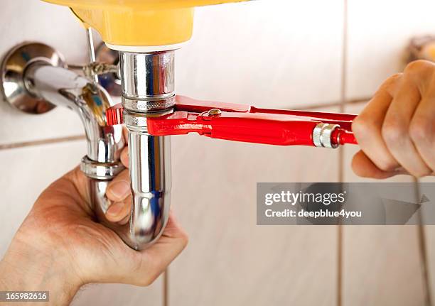 plumber fixing a sink in bathroom - water pipe stock pictures, royalty-free photos & images