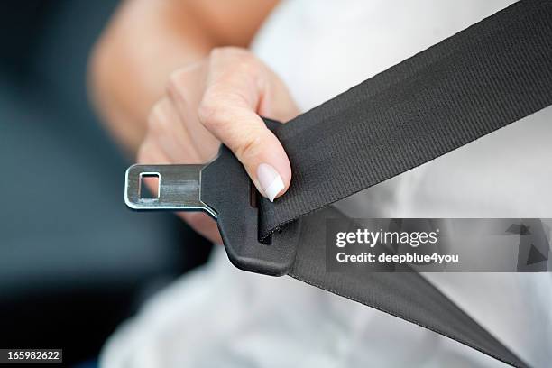 mano tirando de cinturón de seguridad - buckle fotografías e imágenes de stock