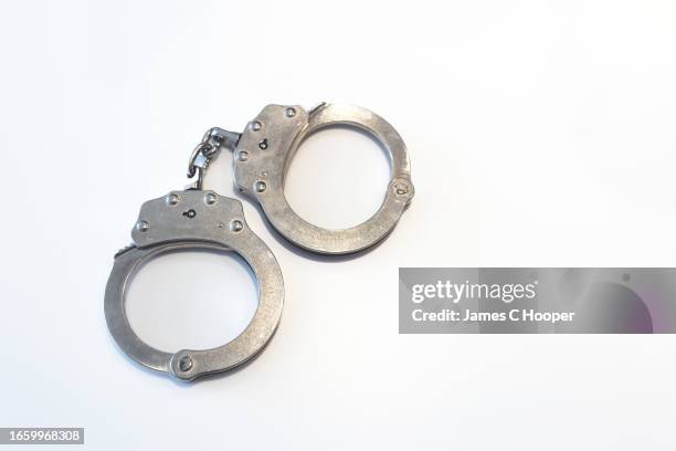 handcuffs on white background 3 - handboeien stockfoto's en -beelden