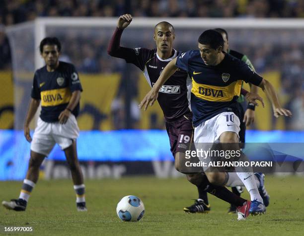 Boca Juniors' midfielder Juan Roman Riquelme vies for the ball with Lanus' midfielder Guido Pizarro during their Argentine First Division football...
