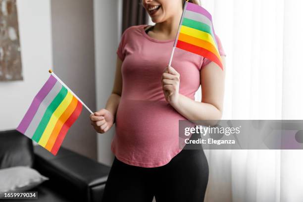 pregnant woman with rainbow flag - lesbian couple green stock pictures, royalty-free photos & images