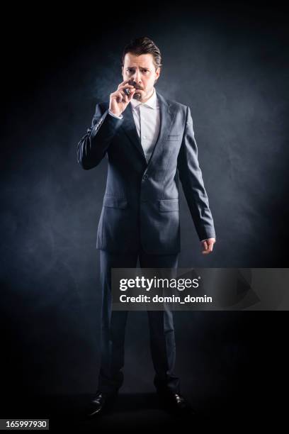 mafia's man in suit smoking cigar, serious face, slicked hair - slicked back hair stock pictures, royalty-free photos & images