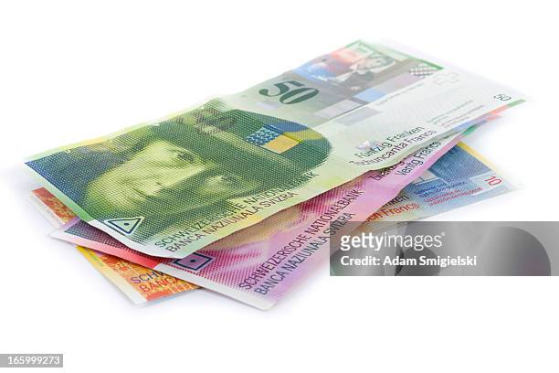 scattered pile of swiss francs banknotes isolated on white - franken stockfoto's en -beelden